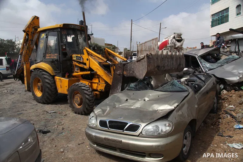 Palestinian police members use a bulldozer to destroy cars during a campaign destroy illegal cars in the West Bank City of Hebron, February 23, 2014. A majority of the so-called "illegal" vehicles are cars bought or stol...