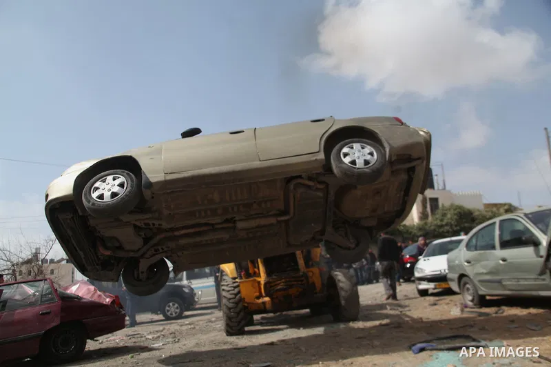 Palestinian police members use a bulldozer to destroy cars during a campaign destroy illegal cars in the West Bank City of Hebron, February 23, 2014. A majority of the so-called "illegal" vehicles are cars bought or stol...