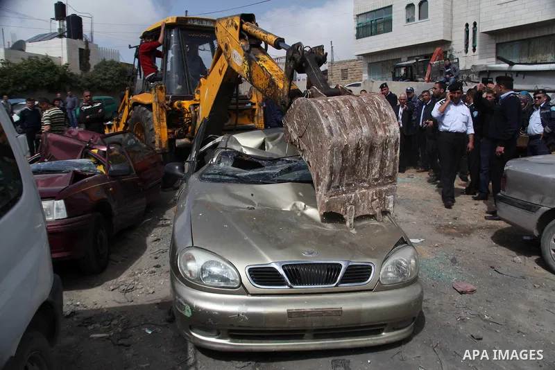 Palestinian police members use a bulldozer to destroy cars during a campaign destroy illegal cars in the West Bank City of Hebron, February 23, 2014. A majority of the so-called "illegal" vehicles are cars bought or stol...
