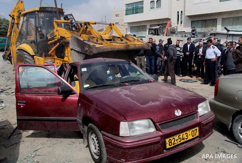 Palestinian police members use a bulldozer to destroy cars during a campaign destroy illegal cars in the West Bank City of Hebron, February 23, 2014. A majority of the so-called "illegal" vehicles are cars bought or stol...