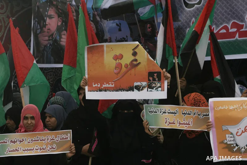 Palestinians hold banners during a protest in front of the Rafah border crossing with Egypt in the southern Gaza Strip on February 24, 2014, to demand that Egypt lift border crossing restrictions. Egypt imposed the restr...