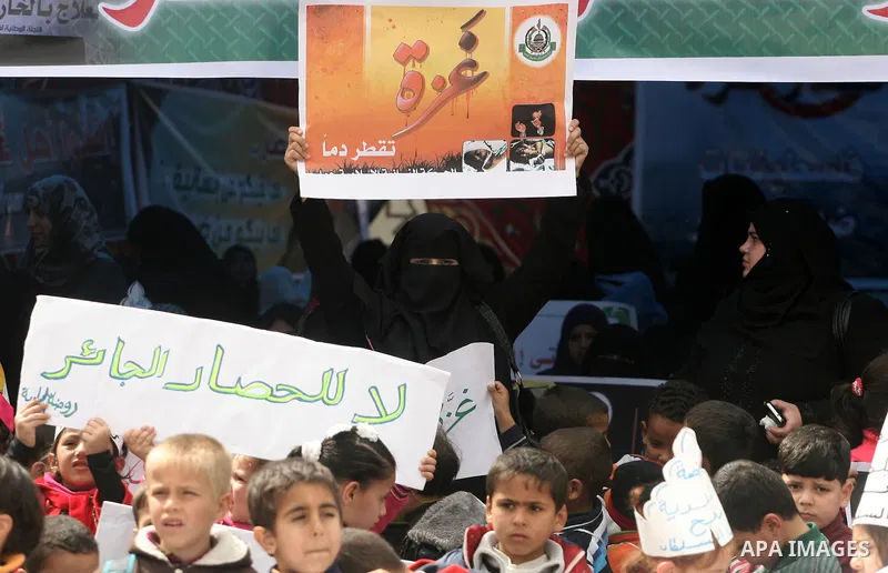 Palestinians hold banners during a protest in front of the Rafah border crossing with Egypt in the southern Gaza Strip on February 24, 2014, to demand that Egypt lift border crossing restrictions. Egypt imposed the restr...