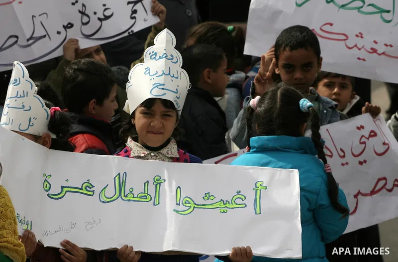 Palestinians hold banners during a protest in front of the Rafah border crossing with Egypt in the southern Gaza Strip on February 24, 2014, to demand that Egypt lift border crossing restrictions. Egypt imposed the restr...