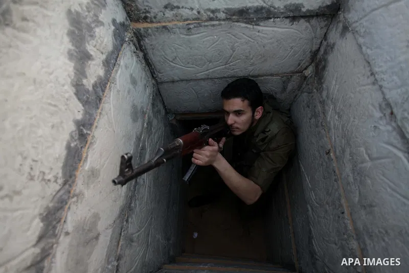 A photo taken on Feb. 17, 2014 shows A Palestinian actor dressed as an Israeli soldier aims his gun from a tunnel during filming in a movie being made in Gaza called, ''Losing Shalit," in Gaza City. "Losing Schalit," cur...