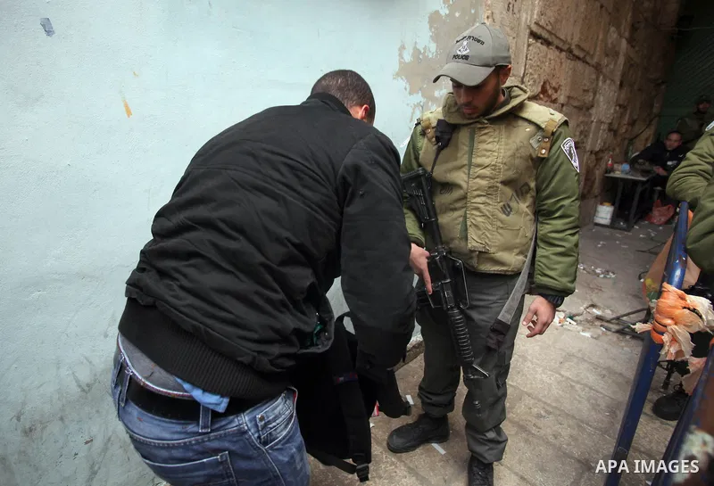 Israeli security forces checks the bag of Palestinian man while he wait to cross an alleyway leading to the al-Aqsa Mosque compound on February 25, 2014 in the Old City of Jerusalem. Israeli police early today entered th...