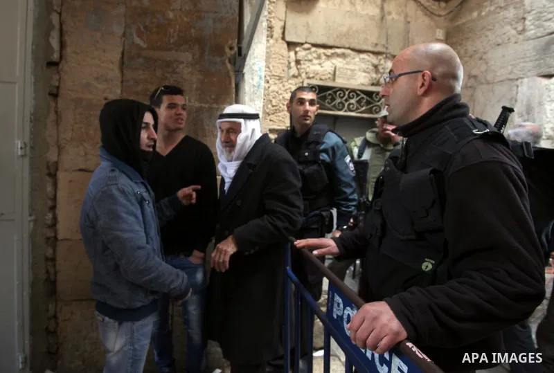 Palestinians scuffle with Israeli security forces standing guard at an alleyway leading to the al-Aqsa Mosque compound on February 25, 2014 in the Old City of Jerusalem. Israeli police early today entered the sensitive A...