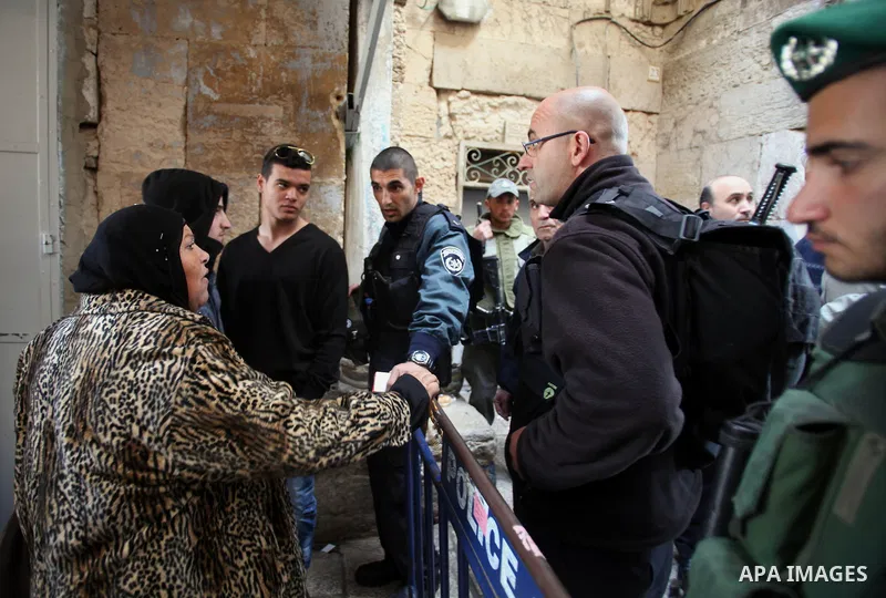A Palestinian woman argues with Israeli security forces standing guard at an alleyway leading to the al-Aqsa Mosque compound on February 25, 2014 in the Old City of Jerusalem. Israeli police early today entered the sensi...