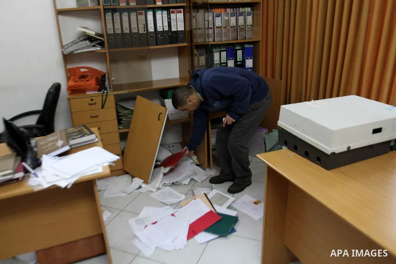 A Palestinian man inspects damage inside the solidarity foundation for human rights after its stormed by Israeli army, in the West Bank city of Nablus, on Feb. 25, 2014. Photo by Nedal Eshtayah