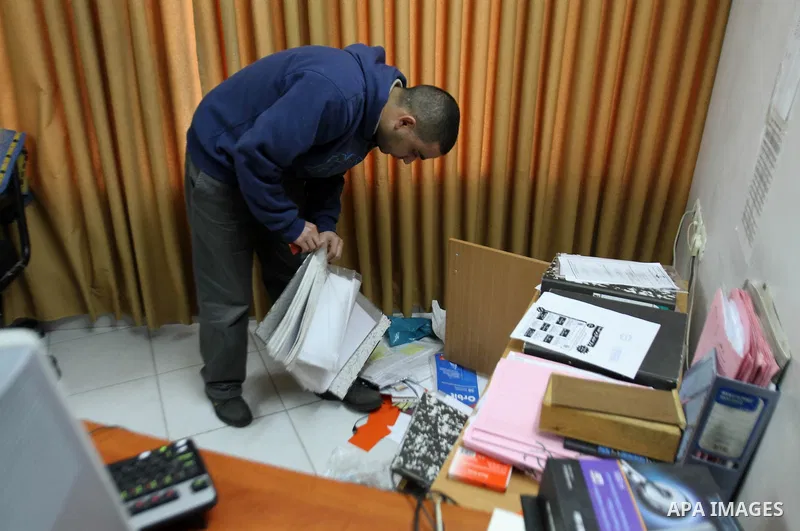A Palestinian man inspects damage inside the solidarity foundation for human rights after its stormed by Israeli army, in the West Bank city of Nablus, on Feb. 25, 2014. Photo by Nedal Eshtayah