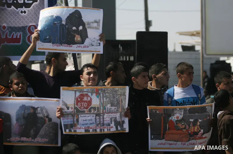 Palestinians hold banners during a protest in front of the Rafah border crossing with Egypt in the southern Gaza Strip on February 24, 2014. to demand that Egypt lift border crossing restrictions. Egypt imposed the restr...