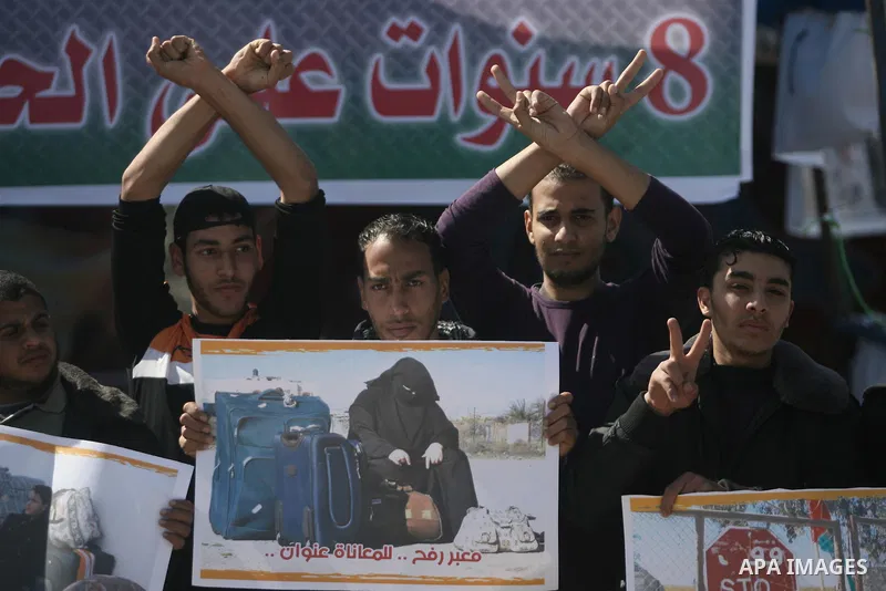 Palestinians hold banners during a protest in front of the Rafah border crossing with Egypt in the southern Gaza Strip on February 24, 2014. to demand that Egypt lift border crossing restrictions. Egypt imposed the restr...