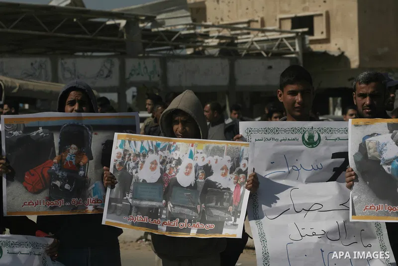 Palestinians hold banners during a protest in front of the Rafah border crossing with Egypt in the southern Gaza Strip on February 24, 2014. to demand that Egypt lift border crossing restrictions. Egypt imposed the restr...