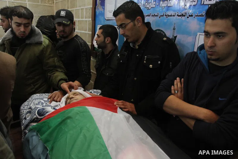 Palestinians gather around the body of the Mufti of Gaza Strip Sheikh Abd al-Karim al-Kahlout during his funeral, in Gaza City on February 25, 2014. Al-Kahlout was one of Gaza's most renowned and respected Muslim clerics...