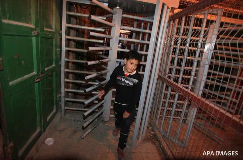 A Palestinian boy passes the gate of the Ibrahimi Mosque in the southern West Bank city of Hebron on February 25, 2014. On February 25, 1994, Israeli settler Baruch Goldstein used an assault rifle to gun down worshippers...