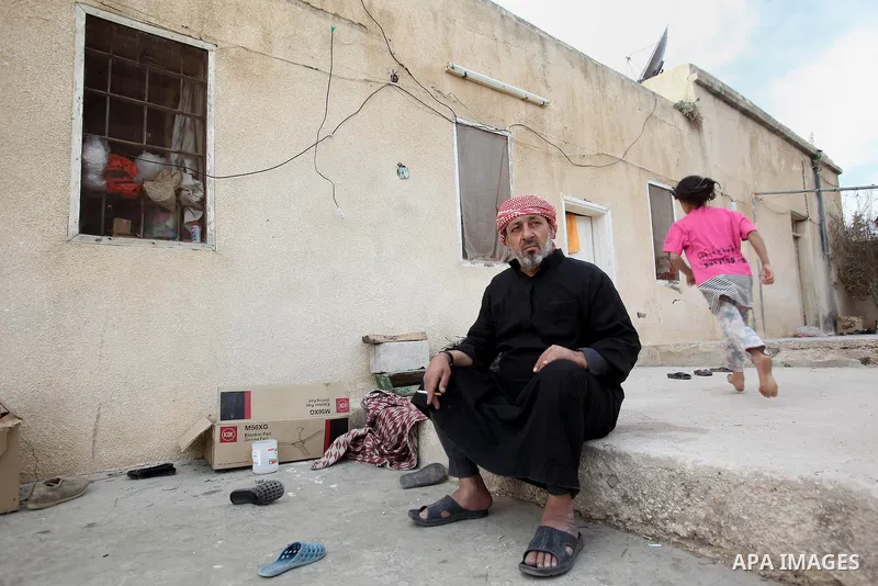 Ahmad Mansour, 54, poses for a picture at his house in the village of al-Kitteh western city of Jerash, 50 km northern the Jordanian capital Amman on February 21, 2014 . Mansour arrived on foot on a stretcher as a Syrian...