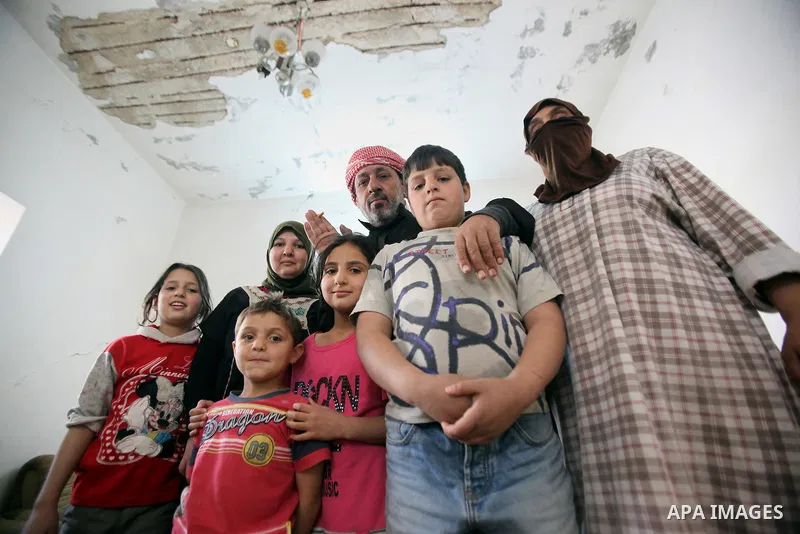 Ahmad Mansour, 54, with his family pose for a picture at his house in the village of al-Kitteh western city of Jerash, 50 km northern the Jordanian capital Amman on February 21, 2014 . Mansour arrived on foot on a stretc...