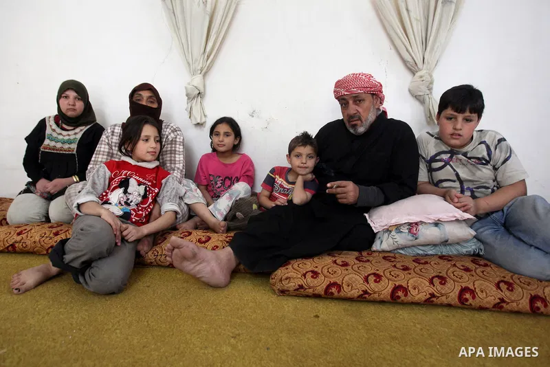 Ahmad Mansour, 54, with his family pose for a picture at his house in the village of al-Kitteh western city of Jerash, 50 km northern the Jordanian capital Amman on February 21, 2014 . Mansour arrived on foot on a stretc...