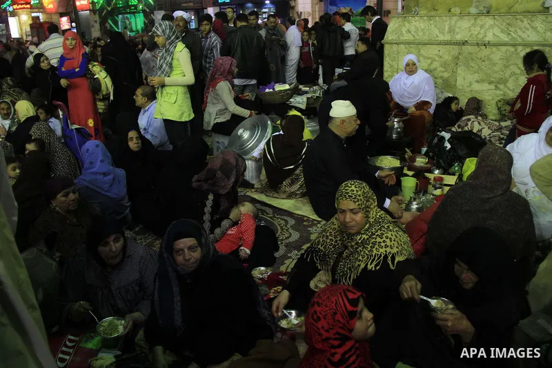 Egyptians eat rice and meats to worshippers after El Ishaa prayers at the Al-Hussein mosque, during celebration day of "Moulid Al-Hussein" the birthday of Prophet Mohammad's grandson Hussein in Cairo, February 25, 2014....