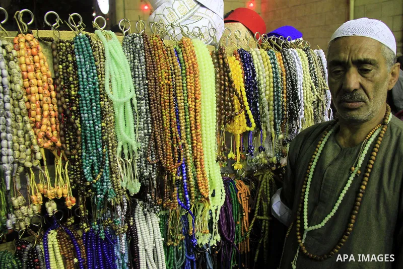 A Egyptian man sells subbah to worshippers after El Ishaa prayers at the Al-Hussein mosque, during celebration day of "Moulid Al-Hussein" the birthday of Prophet Mohammad's grandson Hussein in Cairo, February 25, 2014. P...
