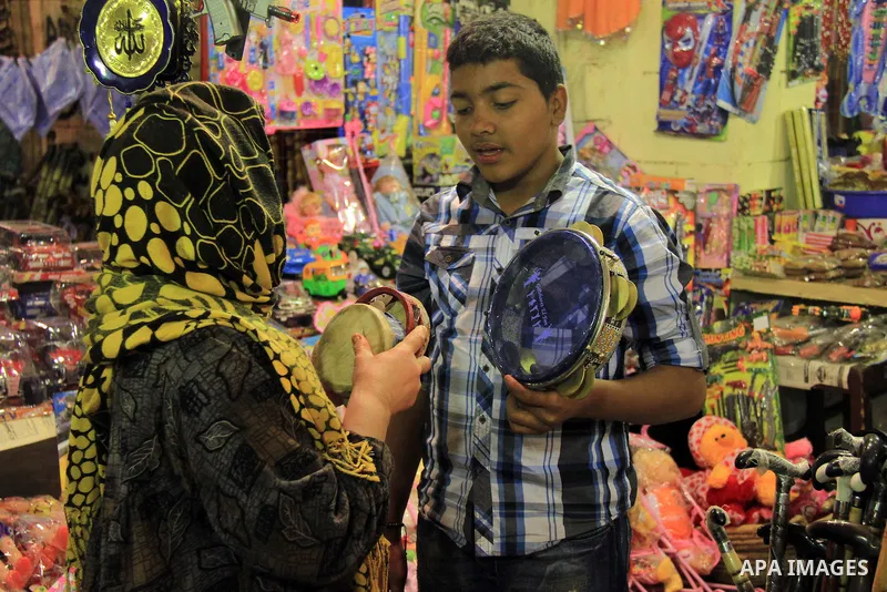 A Egyptian man sells a handicraft to worshippers after El Ishaa prayers at the Al-Hussein mosque, during celebration day of "Moulid Al-Hussein" the birthday of Prophet Mohammad's grandson Hussein in Cairo, February 25, 2...