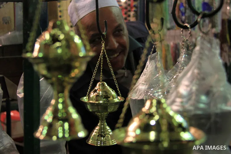 A Egyptian man sells copper works to worshippers after El Ishaa prayers at the Al-Hussein mosque, during celebration day of "Moulid Al-Hussein" the birthday of Prophet Mohammad's grandson Hussein in Cairo, February 25, 2...