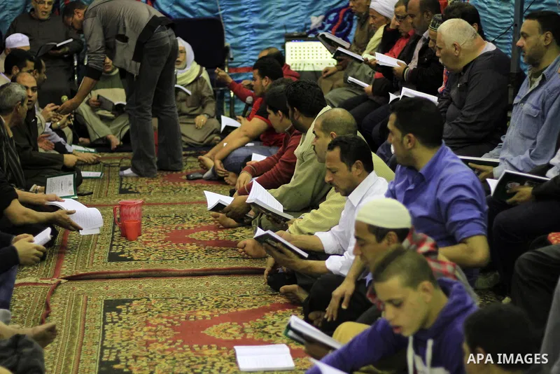 Worshippers read the Koran at the Al-Hussein mosque, during celebration day of "Moulid Al-Hussein" the birthday of Prophet Mohammad's grandson Hussein in Cairo, February 25, 2014. Photo by Mohammed Bendari