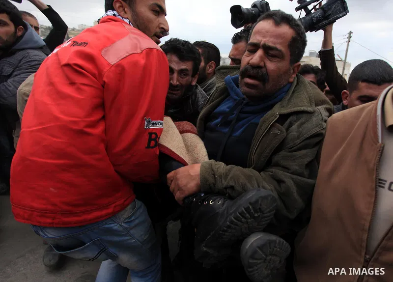 Palestinians carry the body of Muataz Washaha outside his home in the West Bank village of Birzeit, near Ramallah February 27, 2014. Israeli forces opened fire and killed Washaha, whom they were seeking to arrest in the...