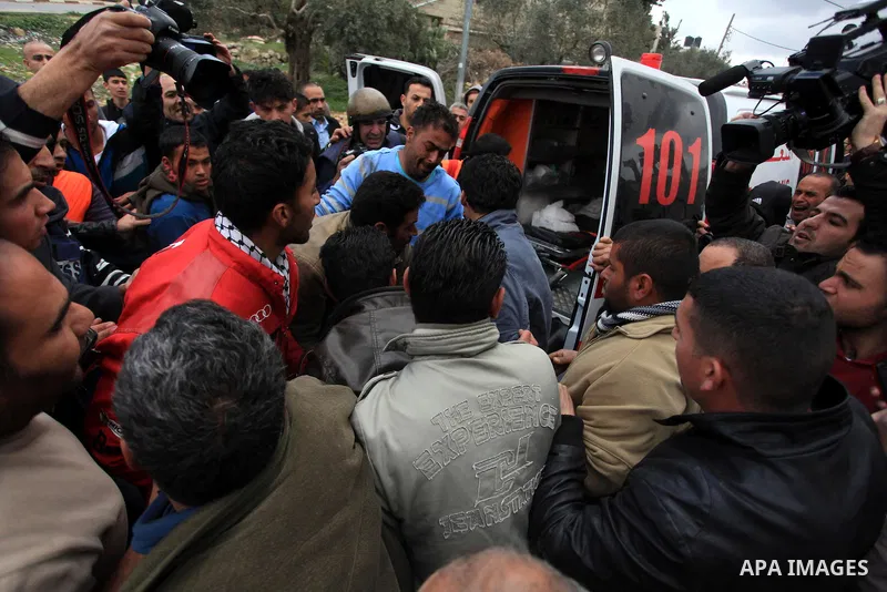 Palestinians carry the body of Muataz Washaha outside his home in the West Bank village of Birzeit, near Ramallah February 27, 2014. Israeli forces opened fire and killed Washaha, whom they were seeking to arrest in the...