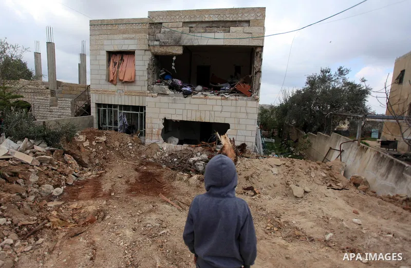 Palestinians inspect the damaged house of Palestinian Moataz Washaha, who died during an Israeli army raid on his home in in the West Bank village of Birzeit, near Ramallah February 27, 2014. Israeli forces opened fire a...