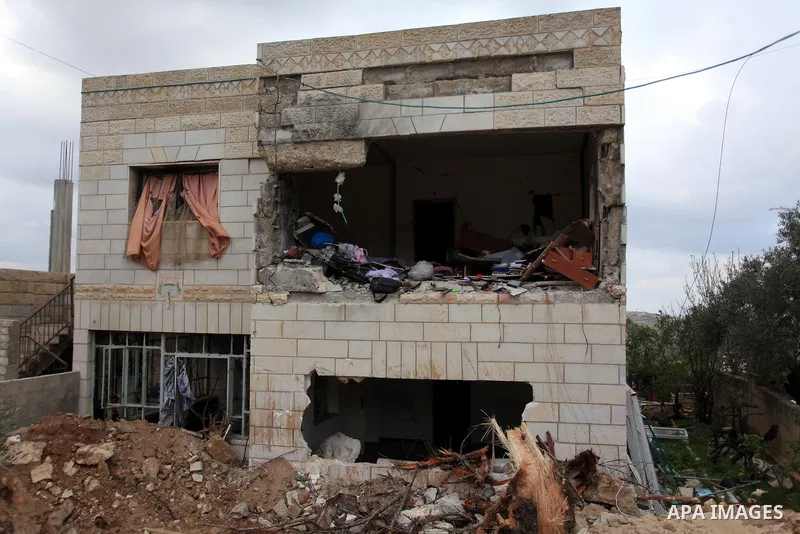 Palestinians inspect the damaged house of Palestinian Moataz Washaha, who died during an Israeli army raid on his home in in the West Bank village of Birzeit, near Ramallah February 27, 2014. Israeli forces opened fire a...