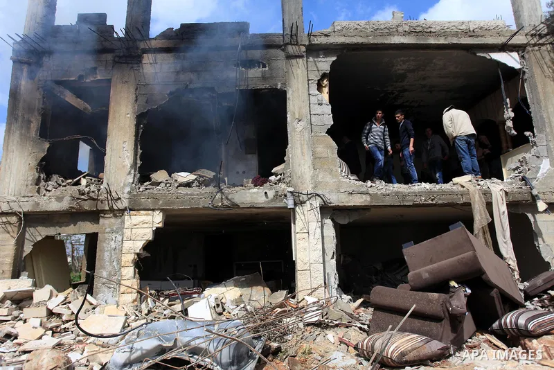 Palestinians inspect the damaged house of Palestinian Moataz Washaha, who died during an Israeli army raid on his home in in the West Bank village of Birzeit, near Ramallah February 27, 2014. Israeli forces opened fire a...