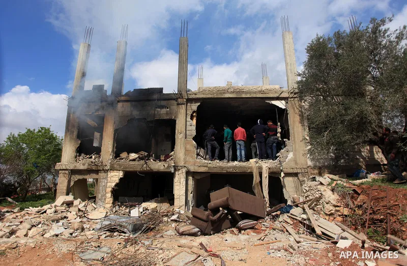 Palestinians inspect the damaged house of Palestinian Moataz Washaha, who died during an Israeli army raid on his home in in the West Bank village of Birzeit, near Ramallah February 27, 2014. Israeli forces opened fire a...