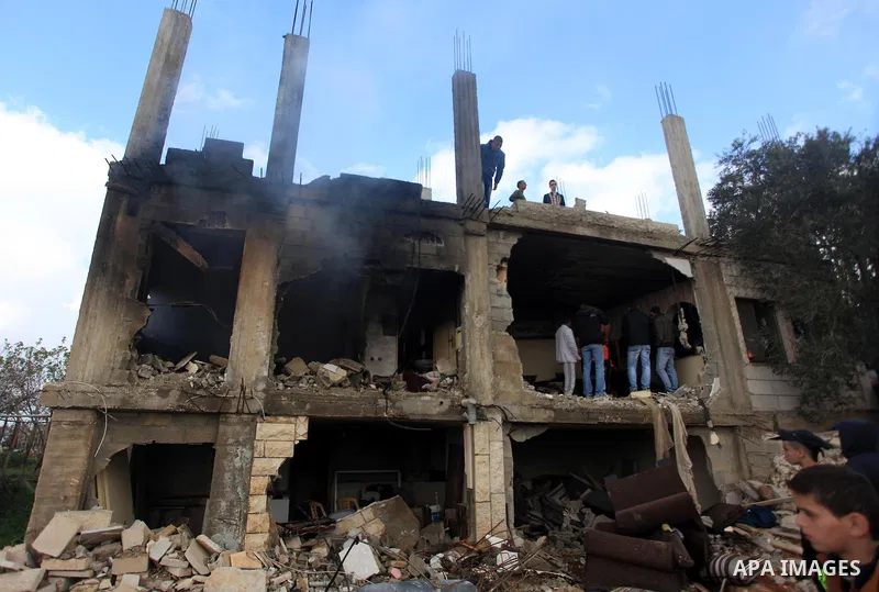 Palestinians inspect the damaged house of Palestinian Moataz Washaha, who died during an Israeli army raid on his home in in the West Bank village of Birzeit, near Ramallah February 27, 2014. Israeli forces opened fire a...
