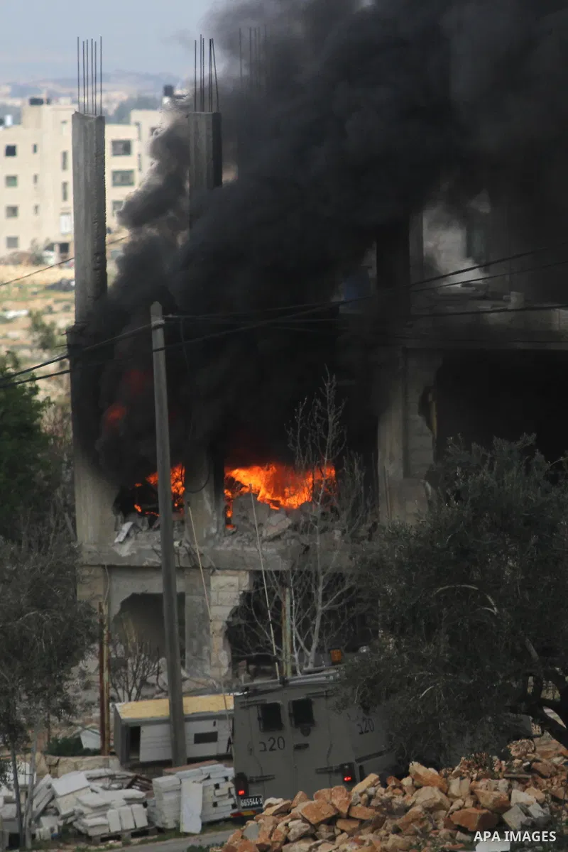 Flames rise from the house of Palestinian Moataz Washaha, who died during an Israeli army raid on his home in the northern West Bank town of Bir Zeit, near Ramallah on February 27, 2014. Israeli forces opened fire and ki...
