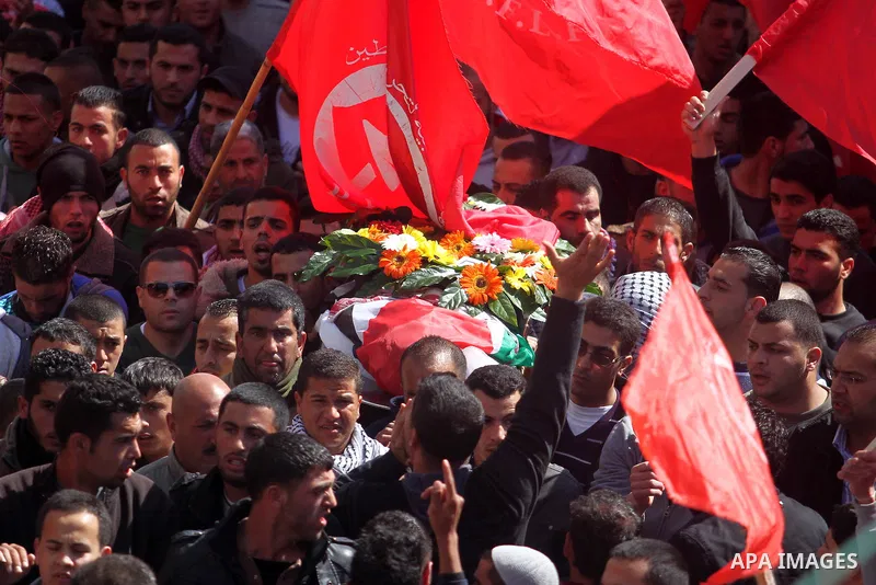 Palestinian mourners carry the body of Mutaz Washaha, 22, a militant from the Popular Front for the Liberation of Palestine (PFLP), from the West Bank town of Birzeit, north of Ramallah, during his funeral 28 February 20...