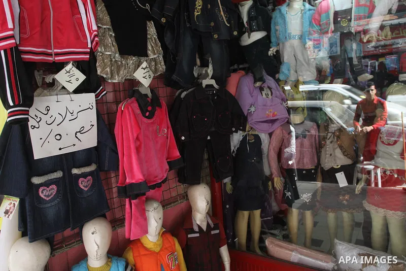 A Palestinian vendor displays his goods at shop in Gaza city, on March 1, 2014. Palestinian vendors campaign discounts on prices of clothes to confront the sharp reduction in demand due to the blockaded territory’s econo...