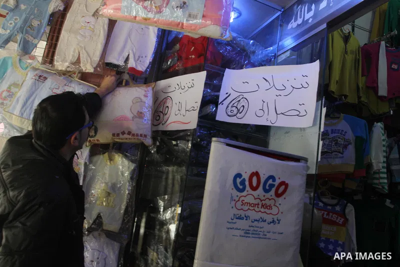 A Palestinian vendor displays his goods at shop in Gaza city, on March 1, 2014. Palestinian vendors campaign discounts on prices of clothes to confront the sharp reduction in demand due to the blockaded territory’s econo...