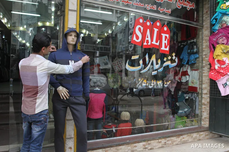 A Palestinian vendor displays his goods at shop in Gaza city, on March 1, 2014. Palestinian vendors campaign discounts on prices of clothes to confront the sharp reduction in demand due to the blockaded territory’s econo...