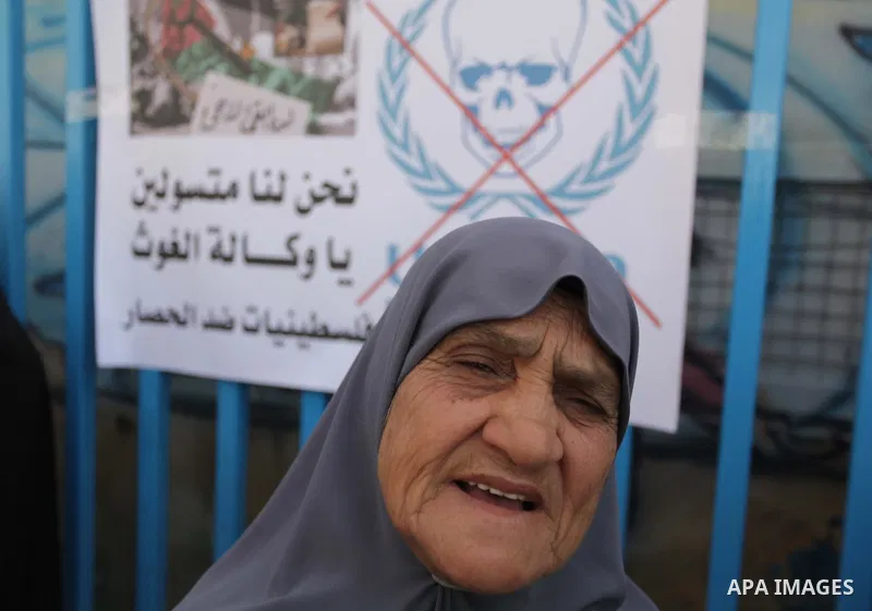 Palestinian women take part in a protest against the decision made by the United Nations Relief and Works Agency (UNRWA) to reduce food aid delivered to the Gaza Strip in front of the UNRWA headquarters in Gaza City on M...