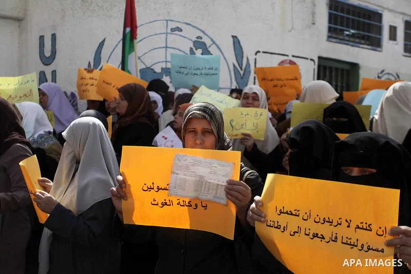 Palestinian women take part in a protest against the decision made by the United Nations Relief and Works Agency (UNRWA) to reduce food aid delivered to the Gaza Strip in front of the UNRWA headquarters in Gaza City on M...
