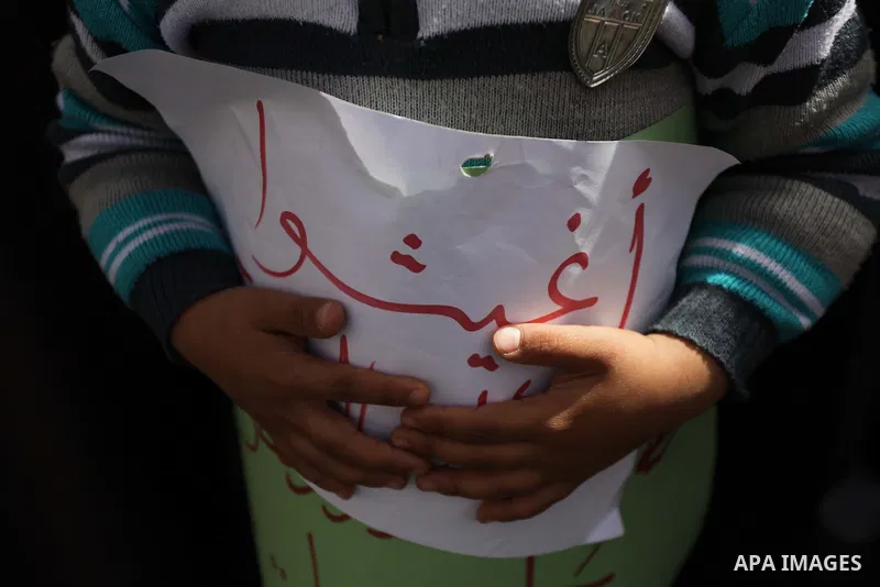 Palestinian women take part in a protest against the decision made by the United Nations Relief and Works Agency (UNRWA) to reduce food aid delivered to the Gaza Strip in front of the UNRWA headquarters in Gaza City on M...