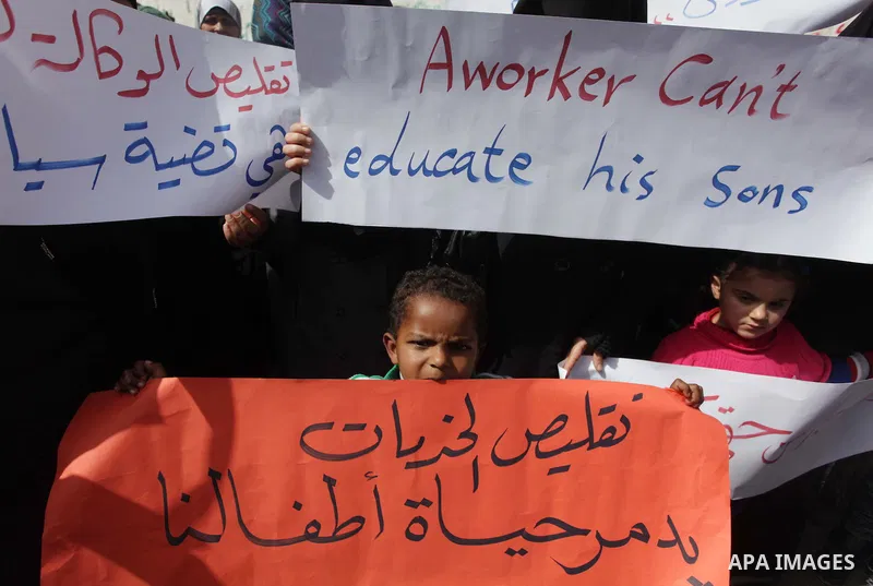 Palestinian women take part in a protest against the decision made by the United Nations Relief and Works Agency (UNRWA) to reduce food aid delivered to the Gaza Strip in front of the UNRWA headquarters in Gaza City on M...