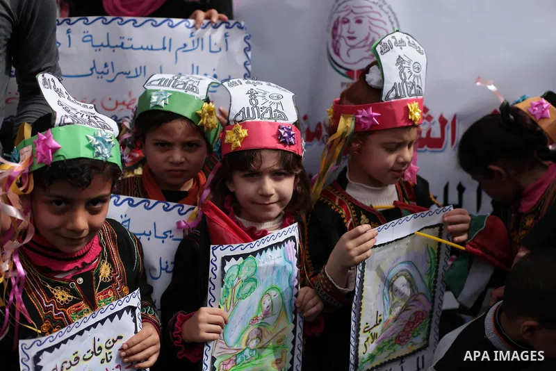 Palestinian women raise placards during a march on the occasion of International Women's Day in Gaza City on March 8, 2014. Photo by Ashraf Amra