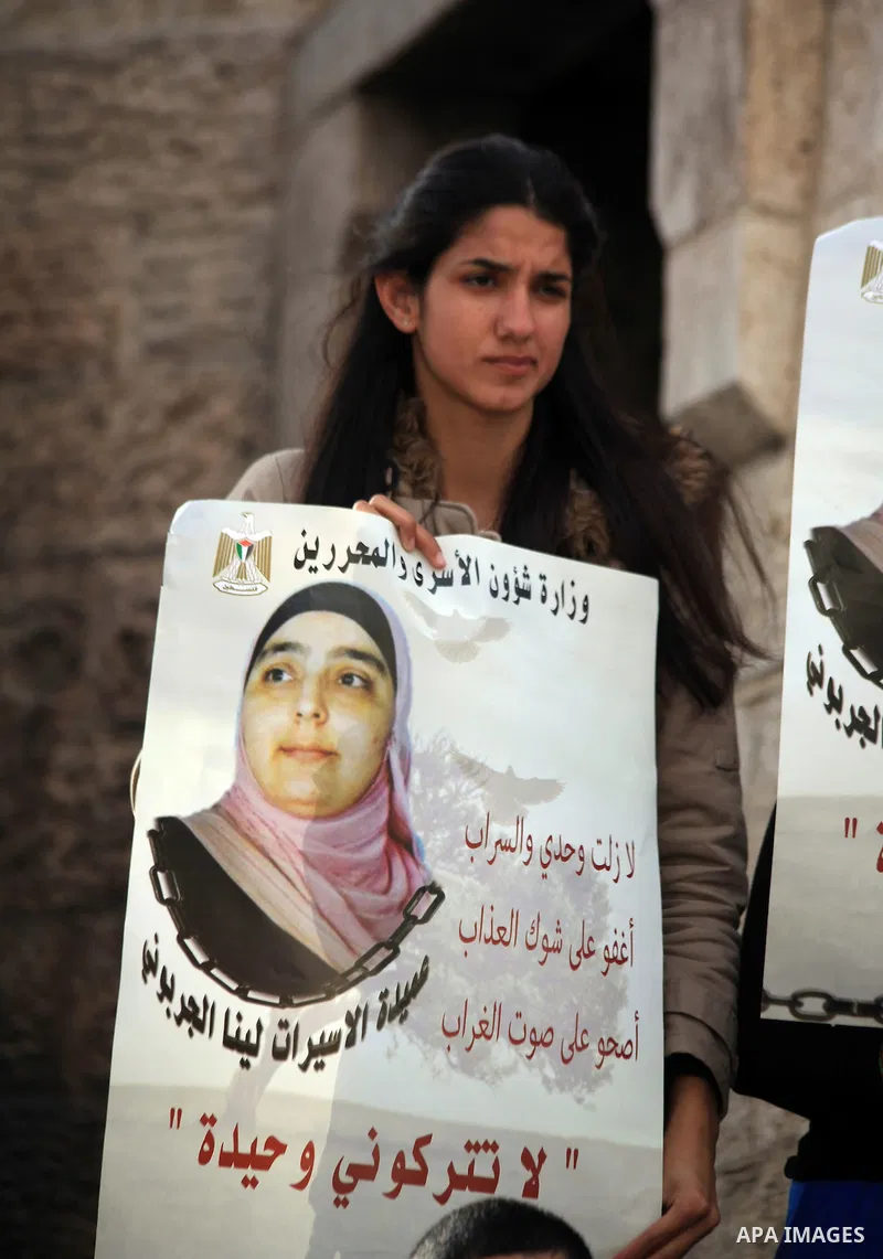 Palestinian protesters hold posters and banners with portraits of Palestinian prisoners in Israeli jail on March 8, 2014 during a demonstration to called for their release at the Damascus Gate in Jerusalem's Old City. Ph...