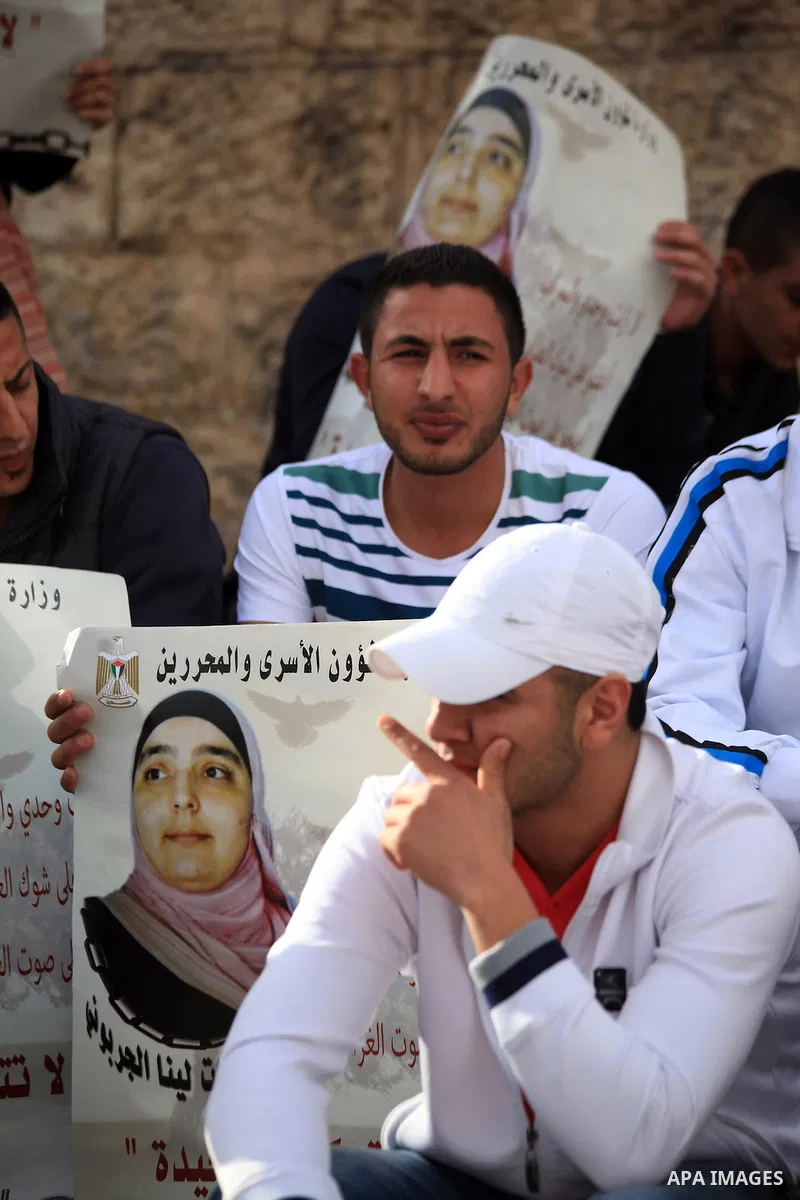 Palestinian protesters hold posters and banners with portraits of Palestinian prisoners in Israeli jail on March 8, 2014 during a demonstration to called for their release at the Damascus Gate in Jerusalem's Old City. Ph...