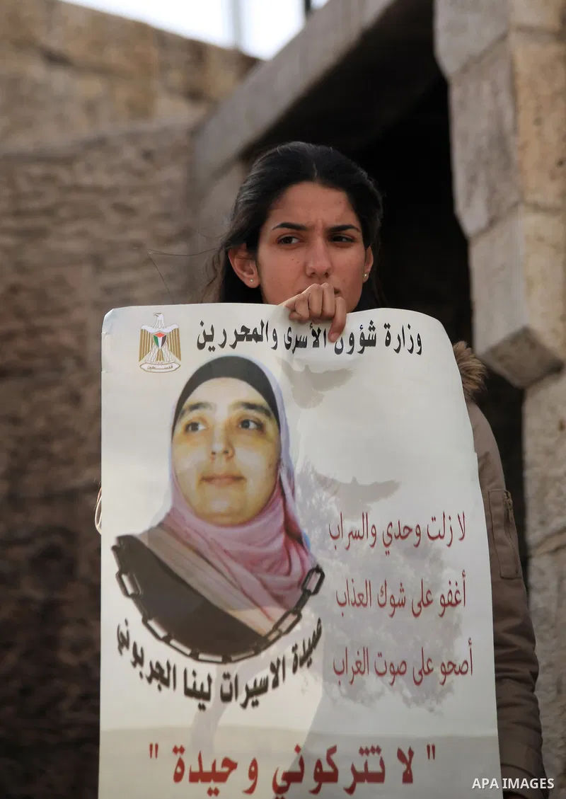 Palestinian protesters hold posters and banners with portraits of Palestinian prisoners in Israeli jail on March 8, 2014 during a demonstration to called for their release at the Damascus Gate in Jerusalem's Old City. Ph...