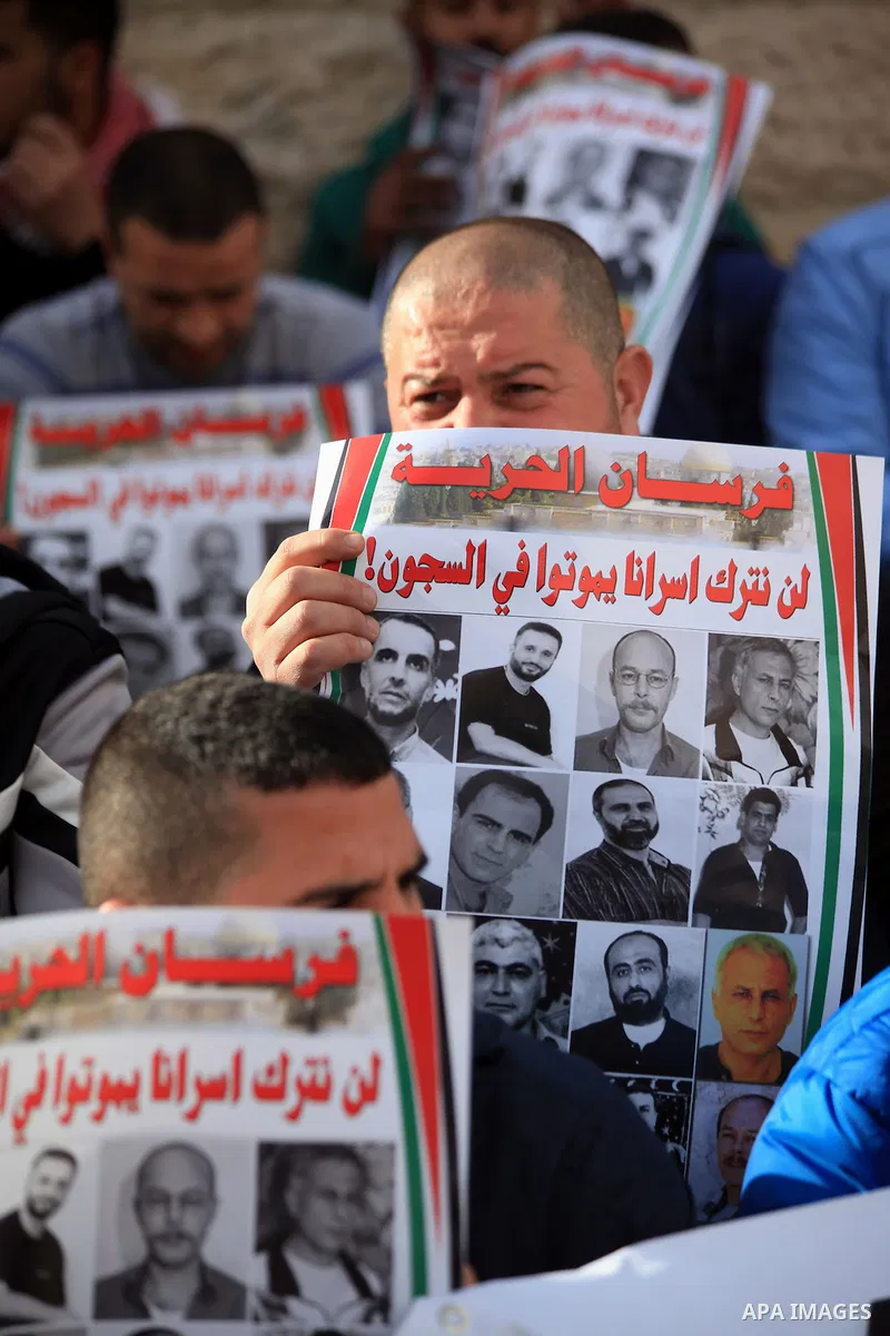 Palestinian protesters hold posters and banners with portraits of Palestinian prisoners in Israeli jail on March 8, 2014 during a demonstration to called for their release at the Damascus Gate in Jerusalem's Old City. Ph...