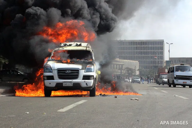 A car belonging to the media burns during a protest by supporters of the Muslim Brotherhood and ousted Egyptian President Mohamed Mursi inside Cairo University, in Cairo, March 9, 2014. Anti-coup students staged on Sunda...
