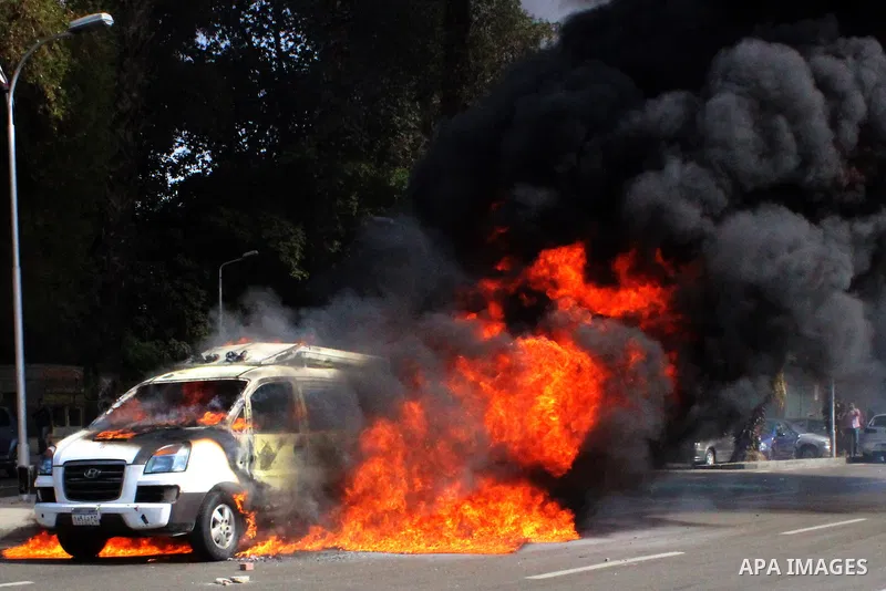 A car belonging to the media burns during a protest by supporters of the Muslim Brotherhood and ousted Egyptian President Mohamed Mursi inside Cairo University, in Cairo, March 9, 2014. Anti-coup students staged on Sunda...