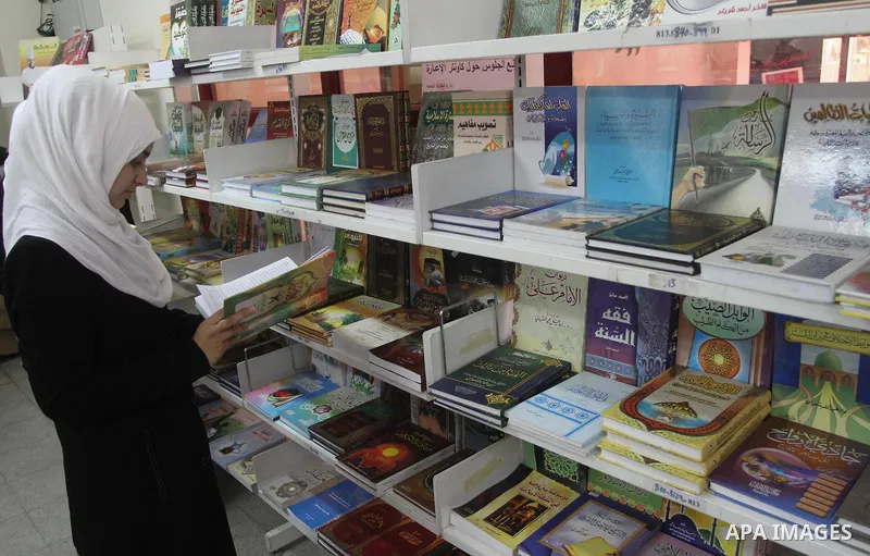 A Palestinian student reads books during the opening of an exhibition "Gaza Hashim" Book, in Gaza city , March 10, 2014. Photo by Mohammed Asad